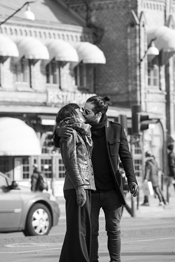 svartvit bild på kyssande ung mörkhårig man och kvinna. man med knut i nacken och solglasögon, kvinna har pagefrisyr